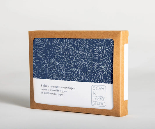 A boxed set of blank notecards, printed with a hand-drawn illustration of a navy blue starry night on uncoated, recyclable paper. Packaged in a compostable box.