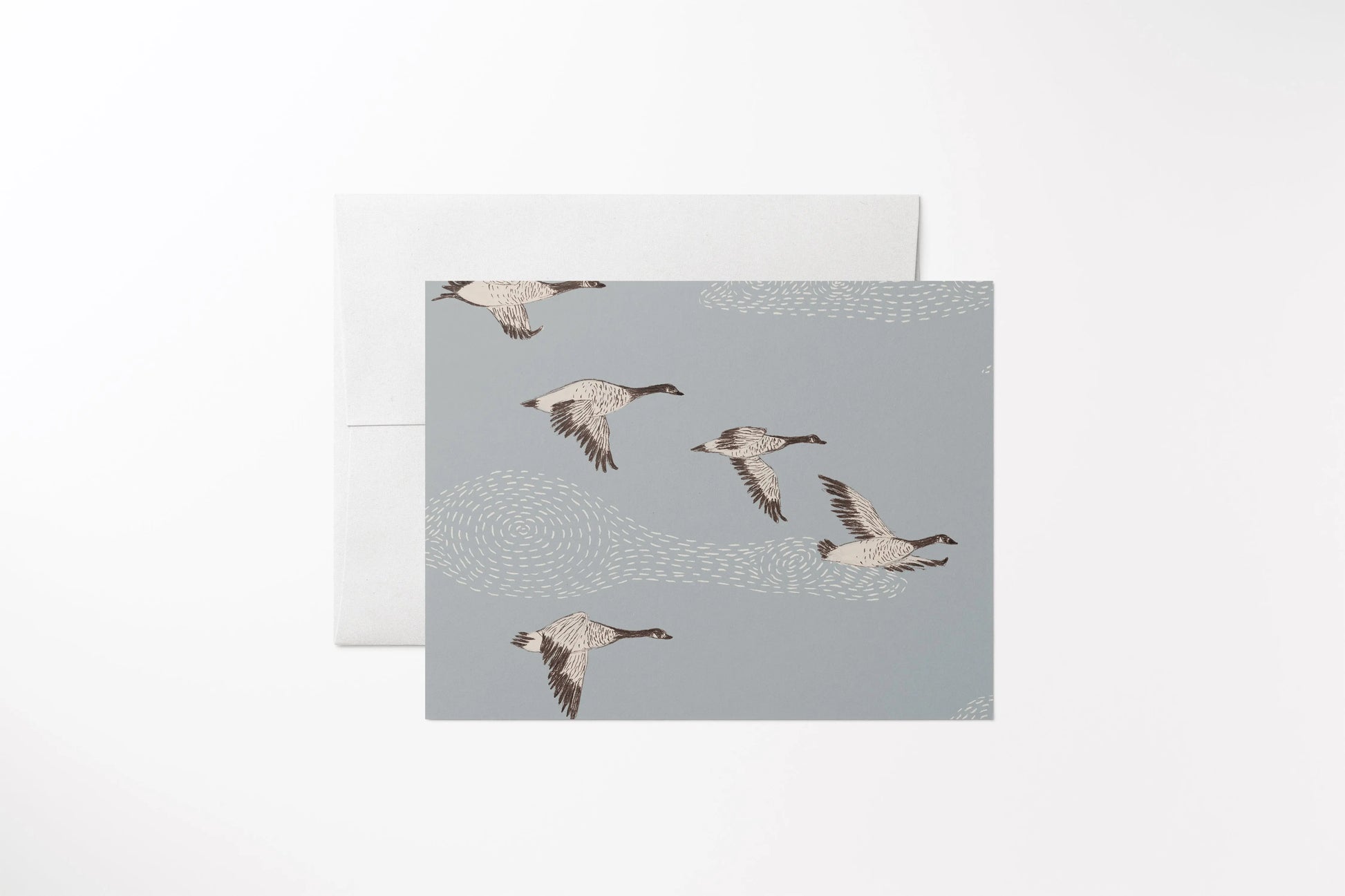 Blank notecard with a hand-drawn geese flying in a stippled sky. Printed on 100% recycled, uncoated paper, with a matching white envelope.