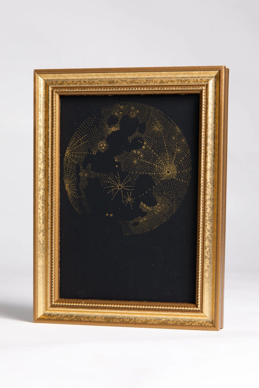 Intricate gold-foil illustration of the moon in a solid-wood frame, painted gold.